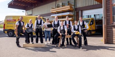 team von holzbau h&ouml;fer vor firmengeb&auml;ude mit fahrzeugen