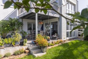 zweigeschossiger anbau an wohnhaus mit terrasse und garten