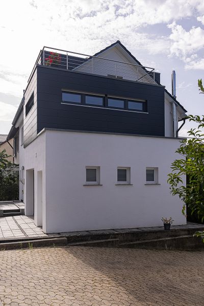 haus mit modernem anbau und dachterrasse