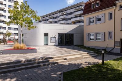 modernes eingeschossiges geb&auml;ude neben &auml;lteren h&auml;usern